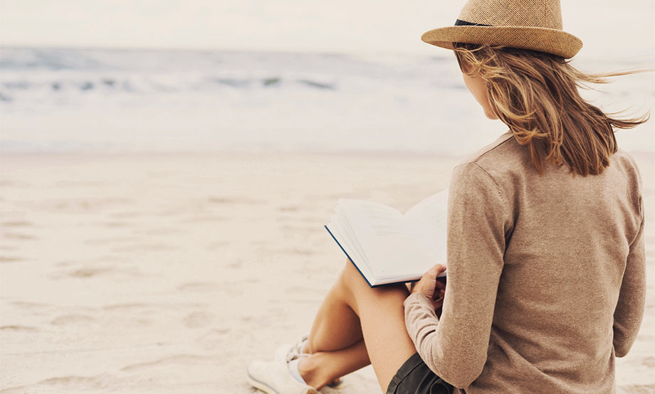 relaxed woman reading on beach